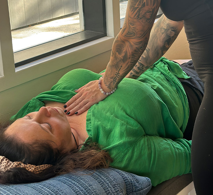 Coach placing a supportive hand on a client during a somatic session